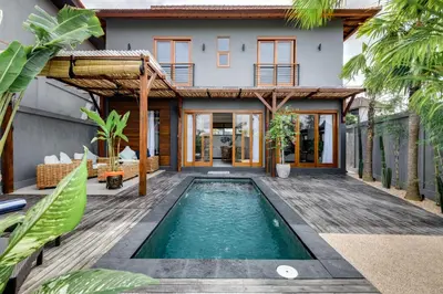 a house with a swimming pool in front of a house at 2 Zen Bali Villa Canggu in Canggu