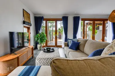 a living room with a couch and a tv at 2 Zen Bali Villa Canggu in Canggu