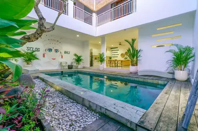 a swimming pool in a villa with a house at Selog Seven in Seminyak