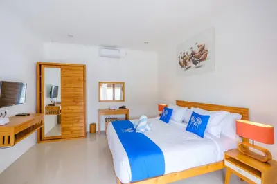 a bedroom with a large bed and a television at Selog Seven in Seminyak