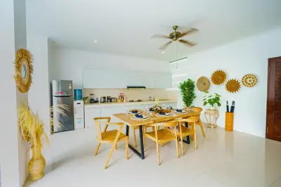 a kitchen with a wooden table and chairs in it at Selog Seven in Seminyak