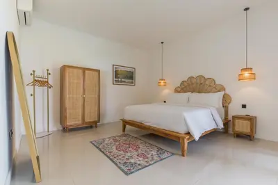 a white bedroom with a bed and a rug at Charming 3 Bedrooms Villa Beach Walking Distance in Seminyak