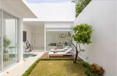 a living room with a white couch and a tree at PEKO VILLA - 1 BED - SEMINYAK in Seminyak