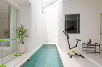 a swimming pool in a white room with a treadmill at PEKO VILLA - 1 BED - SEMINYAK in Seminyak