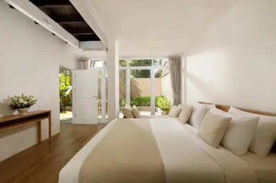 a white bedroom with a large bed with white pillows at Villa Swarna by Nakula in Seminyak