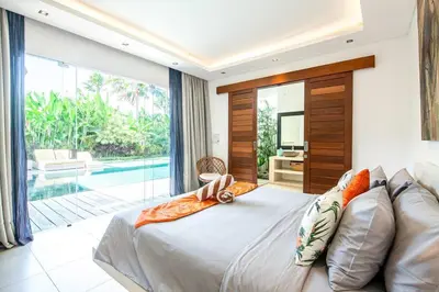 a bedroom with a large bed and a pool at Villa Nikko I - 4Br Villa in Central Seminyak, Steps to Cafés & Shops in Seminyak