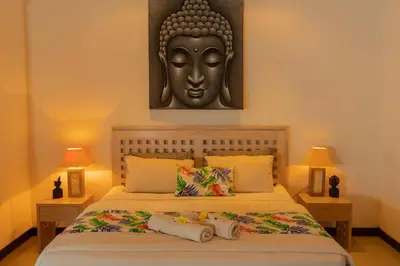 a bedroom with a bed with a statue on the wall at Wyanna Villa LEGIAN in Legian