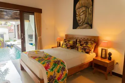 a bedroom with a bed and a picture on the wall at Wyanna Villa LEGIAN in Legian