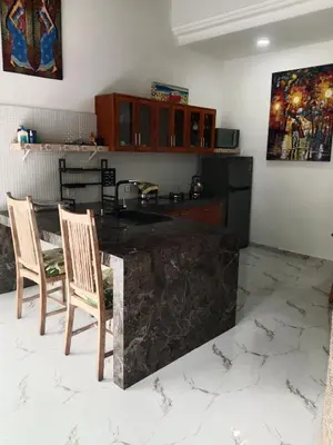 a kitchen with a large marble counter and chairs at Wyanna Villa LEGIAN in Legian