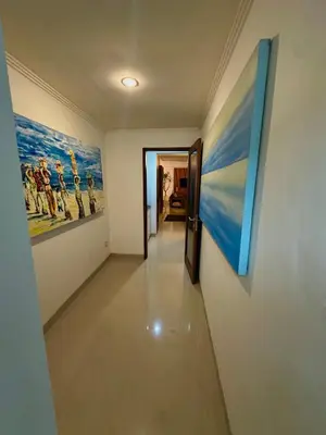 a hallway with two paintings on the walls at Villa Tepi Sungai - 6BR Luxury Private Pool Villa - Seminyak Sleeps 14 in Legian