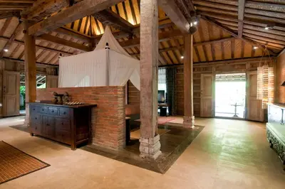 a large room with a brick fireplace in a building at Wahyu wonderful private honeymoon joglo in Seminyak