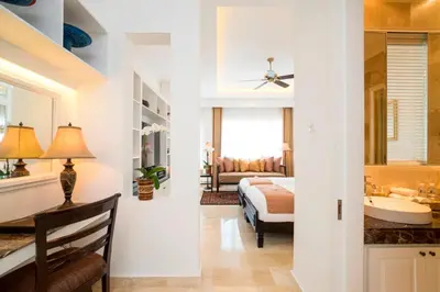 a bedroom with a bed and a bathroom with a sink at The Colony Hotel Bali in Seminyak