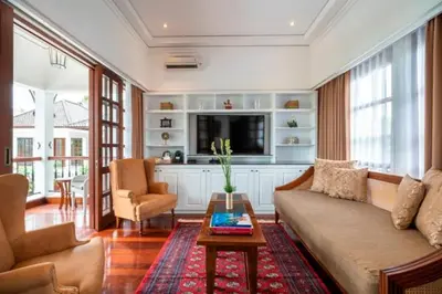 a living room with a couch and a tv at The Colony Hotel Bali in Seminyak