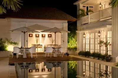 a table and chairs with umbrellas on a house at The Colony Hotel Bali in Seminyak