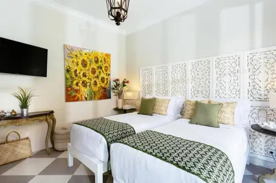 a bedroom with a white bed and a tv at Villa Kayan - Gorgeous 2BR Seminyak gem, fabulous location steps from restaurants, cafes and shopping in Seminyak