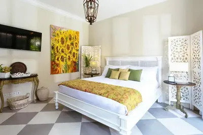 a bedroom with a white bed and a painting on the wall at Villa Kayan - Gorgeous 2BR Seminyak gem, fabulous location steps from restaurants, cafes and shopping in Seminyak