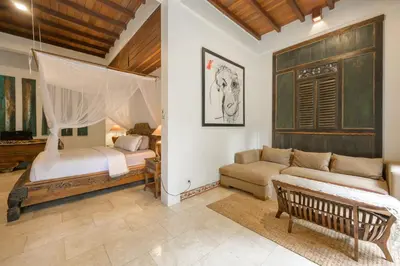a living room with a bed and a couch at The Lavana Ziza Living And Villas Seminyak in Kerobokan
