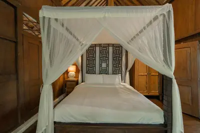 a bedroom with a bed with a canopy at The Lavana Ziza Living And Villas Seminyak in Kerobokan