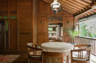 a dining room with a table and chairs on a balcony at The Lavana Ziza Living And Villas Seminyak in Kerobokan