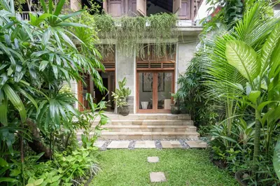 a house with a bunch of plants in front of it at The Lavana Ziza Living And Villas Seminyak in Kerobokan