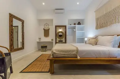a bedroom with a large bed and a mirror at Central 4 bedr villa 5min walk from eat street&Beach in Seminyak