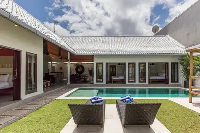 a villa with a swimming pool and a house at Central 4 bedr villa 5min walk from eat street&Beach in Seminyak