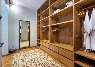 a dressing room with wooden shelves and a mirror at Villa Wolfe by Villa Finder in Seminyak