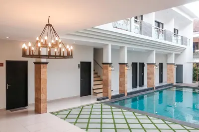 a large swimming pool with a chandelier in a building at Guyana Hotel in Kuta