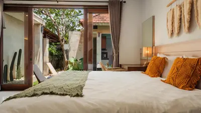 a bedroom with a large bed and a large window at Cosy and Cheerful 2 Bedroom villa 5mins to Finns in Canggu