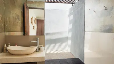 a bathroom with a stone sink and a shower at Cosy and Cheerful 2 Bedroom villa 5mins to Finns in Canggu