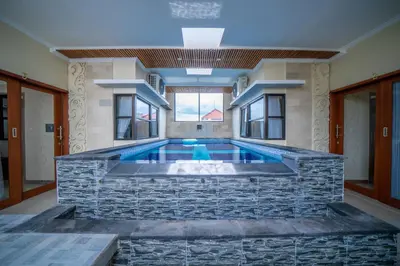 a large swimming pool with a stone wall at Padma Lodge Legian in Seminyak