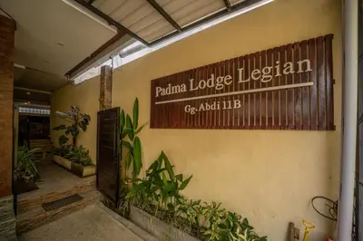 a sign on the side of a building with plants at Padma Lodge Legian in Seminyak