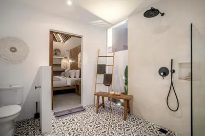 a bathroom with a shower and a toilet and a bedroom at Villa Cocotier by Alfred in Bali in Seminyak