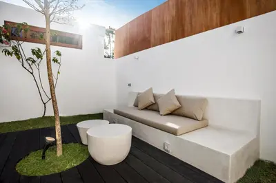 a living room with a couch and a tree at Villa Cocotier by Alfred in Bali in Seminyak