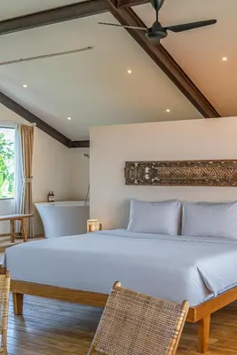 a bedroom with a large bed and two chairs at Villa Elma - Huge 2-bedroom pool villa in Umalas! in Seminyak