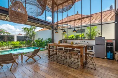 a kitchen with a table and chairs and a pool at Villa Elma - Huge 2-bedroom pool villa in Umalas! in Seminyak