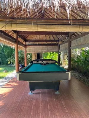 a pool table sitting under a pavilion with a pool table at KUTA - 4BR Villa with Private XL Pool in Kuta
