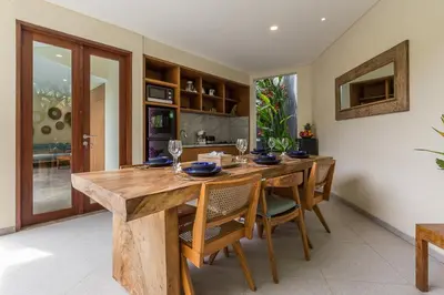 a dining room with a wooden table and chairs at Ajiorqo Villa in Seminyak
