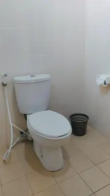 a bathroom with a white toilet in a room at PURNAMA HOUSE KUTA in Kuta