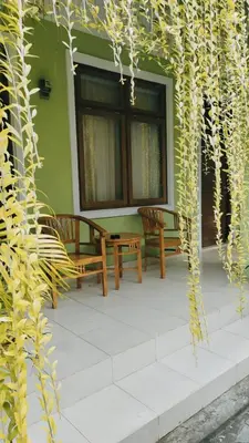 two benches sitting on a patio with a building at PURNAMA HOUSE KUTA in Kuta