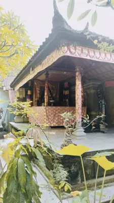 a building with a fountain in front of it at PURNAMA HOUSE KUTA in Kuta