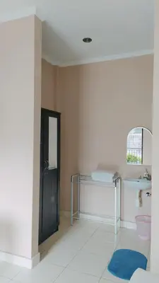 a bathroom with a sink and a mirror at PURNAMA HOUSE KUTA in Kuta