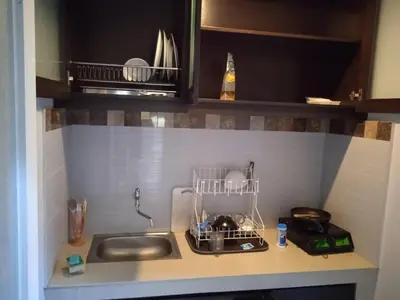 a kitchen counter with a sink and a drying rack at NEW KUBU DI BUKIT apartemen & motor bike rental near beach and 10 minute to airpot in Jimbaran