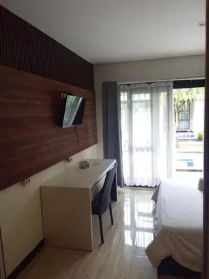 a hotel room with a bed and a desk with a television at NEW KUBU DI BUKIT apartemen & motor bike rental near beach and 10 minute to airpot in Jimbaran