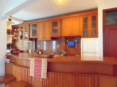 a kitchen with wooden cabinets and a wooden counter top at Villa Cantik Kuta Regency in Kuta