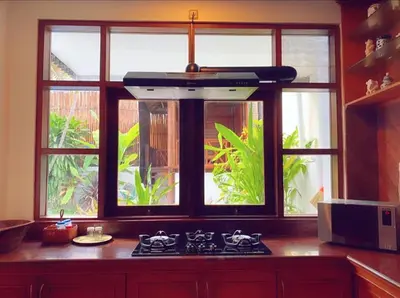 a kitchen with a stove and a window at Villa Cantik Kuta Regency in Kuta