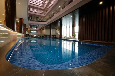 a large swimming pool with blue tiles in a building at Dream of Aventus Hotel Kuta in Kuta