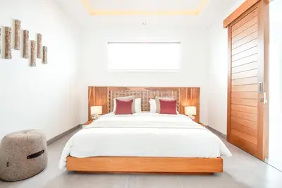 a bedroom with a large bed and a chair at Exquisite 4Bd Gem, 5min to Finns Coastal Vibe in Canggu