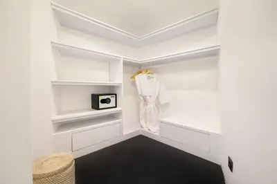 a walk in closet with white walls and shelves at Villa Rose in Seminyak