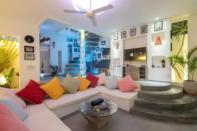 a living room with a white couch with colorful pillows at PROMO Modern Seminyak Pvt Villa with Pool and Parking in Seminyak